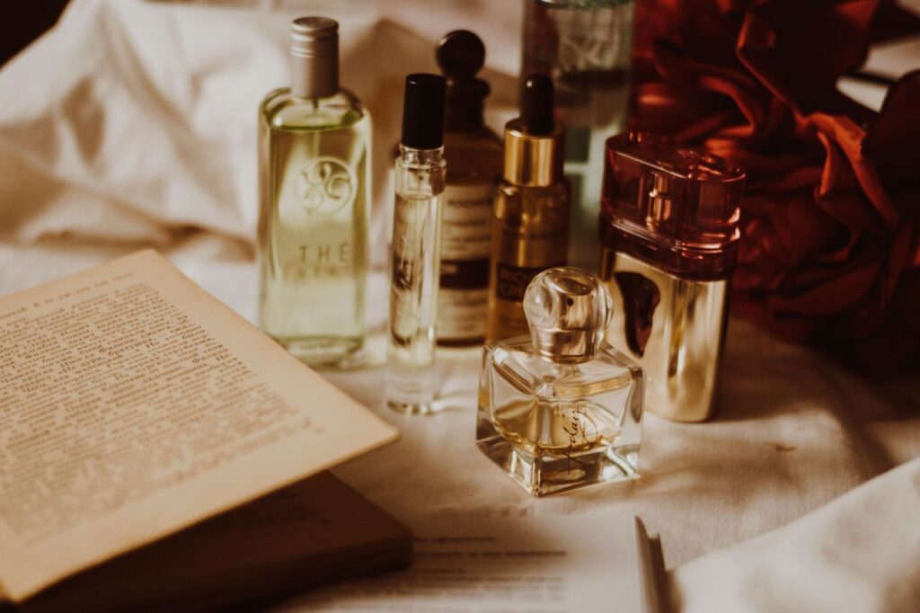 pexels photo 954405 954405 Aesthetic still life of assorted perfume bottles and an open book on a table.